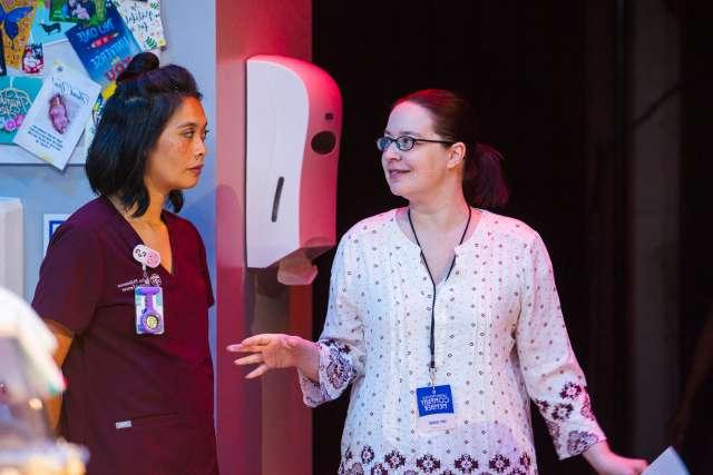 NICU nurse Emily Rogers works with actress Tiffany Villarin on stage.